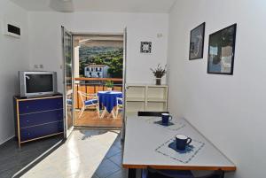 een woonkamer met een tafel en een televisie bij Apartments by the sea Pasadur, Lastovo - 8351 in Ubli