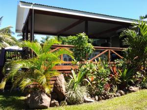 a house with a bunch of plants in front of it at Te Akapuao Studio Villas in Rarotonga