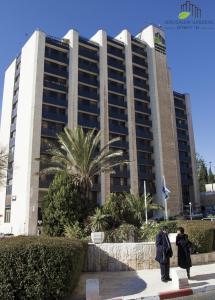 dos personas parados frente a un gran edificio en Jerusalem Gardens Hotel, en Jerusalén