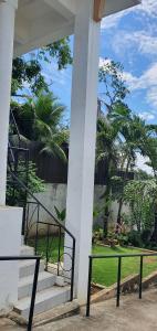 a porch with a staircase and some palm trees at Lola's Guest House in Mactan
