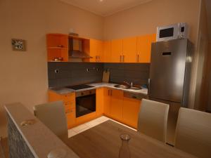 a kitchen with orange cabinets and a stainless steel refrigerator at Apartments by the sea Ubli, Lastovo - 8354 in Ubli