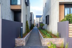 an alley between two buildings with plants at URBAN RETREAT in Christchurch