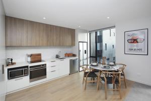 uma cozinha com mesa e cadeiras num quarto em URBAN RETREAT em Christchurch