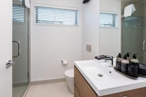 Baño blanco con lavabo y aseo en URBAN RETREAT en Christchurch