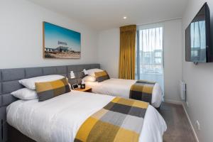 um quarto de hotel com duas camas e uma televisão em URBAN RETREAT em Christchurch