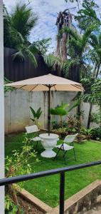 a table and chairs and an umbrella in a yard at Lola's Guest House in Mactan
