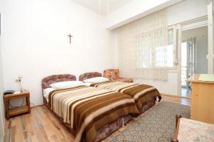 twee bedden in een kamer met een kruis aan de muur bij Rooms with a swimming pool Preko, Ugljan - 8180 in Preko