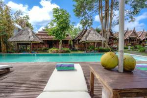 um resort com uma piscina e uma mesa com um coco em My Dream Bali em Uluwatu