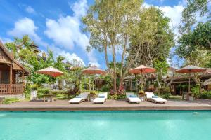 - une piscine avec des chaises longues et des parasols dans l'établissement My Dream Bali, à Uluwatu