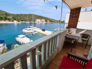 uma varanda com vista para uma marina com barcos na água em Apartments and rooms by the sea Zaglav, Dugi otok - 8170 em Sali