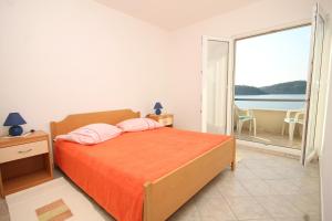 ein Schlafzimmer mit einem Bett und einem großen Fenster in der Unterkunft Apartments by the sea Ubli, Lastovo - 8355 in Ubli