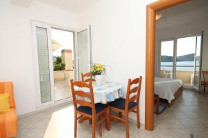 a dining room with a table and a view of the ocean at Apartments by the sea Ubli, Lastovo - 8355 in Ubli