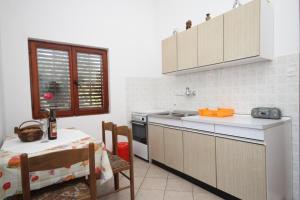 a kitchen with a sink and a table with at Apartments with a parking space Zdrelac, Pasman - 8396 in Ždrelac