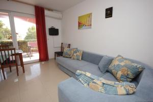 a living room with a blue couch and a table at Apartments by the sea Pasman - 8217 in Pašman