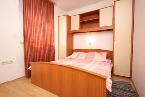 Schlafzimmer mit einem Bett mit einem Kopfteil aus Holz in der Unterkunft Apartments by the sea Pasman - 8217 in Pašman