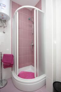 ein Bad mit einer Dusche und rosafarbenen Fliesen in der Unterkunft Apartments by the sea Pasman - 8217 in Pašman