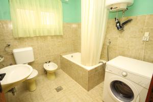 a bathroom with a toilet a sink and a washing machine at Seaside holiday house Kali, Ugljan - 8429 in Kali +23 photos