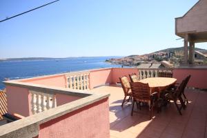 a table and chairs on a balcony with a view of the water at Seaside holiday house Kali, Ugljan - 8429 in Kali