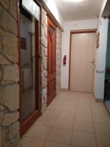einen Flur mit einer Tür und einer Steinmauer in der Unterkunft Apartments with a parking space Ugljan - 8527 in Ugljan