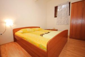 um quarto com uma cama com lençóis amarelos e um candeeiro em Apartments by the sea Tkon, Pasman - 8303 em Tkon