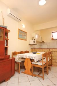 uma cozinha com mesa e cadeiras num quarto em Apartments by the sea Tkon, Pasman - 8303 em Tkon