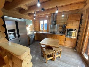 a kitchen with wooden cabinets and a wooden table in a cabin at Chalet Pra-Loup, 5 pièces, 8 personnes - FR-1-165A-126 in Uvernet