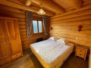 um quarto com uma cama num chalé de madeira em Chalet Pra-Loup, 5 pièces, 8 personnes - FR-1-165A-126 em Uvernet