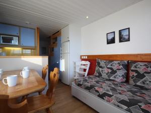 sypialnia z łóżkiem i stołem oraz kuchnią w obiekcie Duplex au calme avec balcon - 6 pers - FR-1-346-335 w mieście Arc 1800