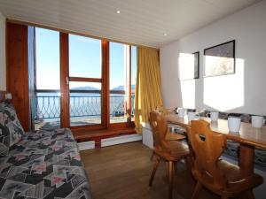 sypialnia ze stołem i krzesłami oraz dużym oknem w obiekcie Duplex au calme avec balcon - 6 pers - FR-1-346-335 w mieście Arc 1800