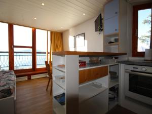 kuchnia z białymi szafkami i widokiem na wodę w obiekcie Duplex au calme avec balcon - 6 pers - FR-1-346-335 w mieście Arc 1800