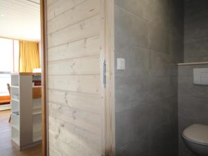 łazienka z toaletą i drewnianą ścianą w obiekcie Duplex au calme avec balcon - 6 pers - FR-1-346-335 w mieście Arc 1800