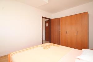 a bedroom with a bed and a wooden cabinet at Apartment Kukljica 8478a in Kukljica