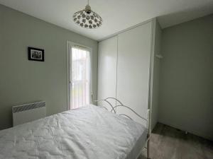 une chambre avec un lit blanc et une fenêtre dans l'établissement T2 Confortable à Cambo-les-Bains, 1er Étage, Parking, Wi-Fi, Proche Centre, Quartier Calme - FR-1-495-103, à Cambo-les-Bains