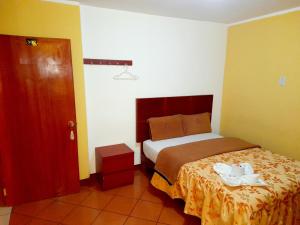 um quarto com uma cama num quarto com uma porta em Hospedaje Las Lilas em Huancayo