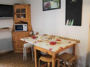 a kitchen with a wooden table with chairs and a counter at Appartement Vars-Sainte-Marie, 2 pièces, 4 personnes - FR-1-330B-196 in Vars