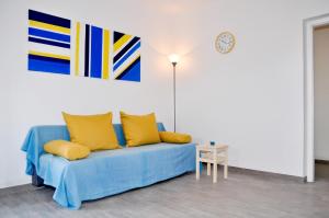 a living room with a blue couch with yellow pillows at Apartments by the sea Razanj, Rogoznica - 8365 in Rogoznica