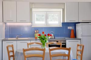 a kitchen with a table with a vase of flowers on it at Apartments by the sea Razanj, Rogoznica - 8365 in Rogoznica