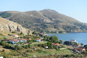 a village on a hill next to a body of water at Sunset Hotel in Agios Ioannis Kaspaka