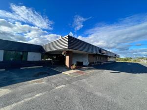 a building with a black roof and a parking lot at Lively Inn and Suites - Sudbury in Naughton