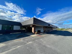 un edificio con techo negro y aparcamiento en Lively Inn and Suites - Sudbury, en Naughton