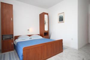 um quarto com uma cama com uma cabeceira em madeira e um espelho em Studio Zaklopatica 8393a em Lastovo