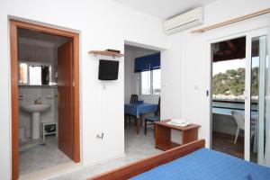a bedroom with a bed and a bathroom with a sink at Studio Zaklopatica 8393a in Lastovo
