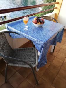 a table with a bowl of fruit and a glass of juice at Studio Zaklopatica 8393a in Lastovo +13 photos