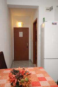 a table with a vase of flowers on a table with a refrigerator at Apartments by the sea Zaklopatica, Lastovo - 8393 in Lastovo