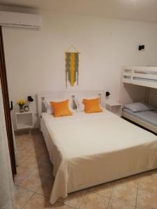 a bedroom with a large white bed with orange pillows at Apartments by the sea Zaklopatica, Lastovo - 8393 in Lastovo