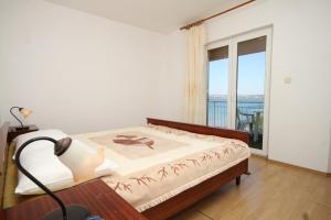 1 dormitorio con cama y ventana grande en Apartments and rooms by the sea Tkon, Pasman - 8377, en Tkon