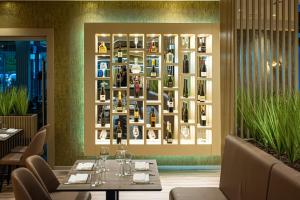 a dining room with a wall of wine bottles at Hotel Paka in Velenje