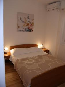 a bedroom with a bed and two lamps on two tables at Double Room Tkon 8377d in Tkon