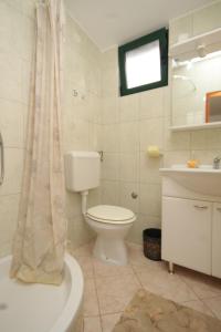 a white bathroom with a toilet and a sink at Seaside house for families with children Cove Sveti Ante, Pasman - 8499 in Kraj
