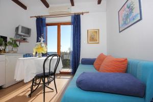 a living room with a blue couch and a table at Apartments and rooms with parking space Brsecine, Dubrovnik - 8541 in Zaton
